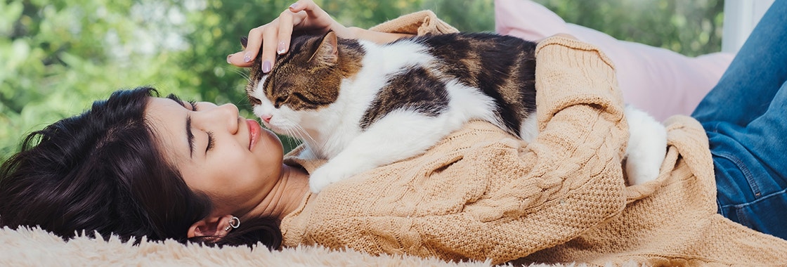 a cat is sitting on a women's chests